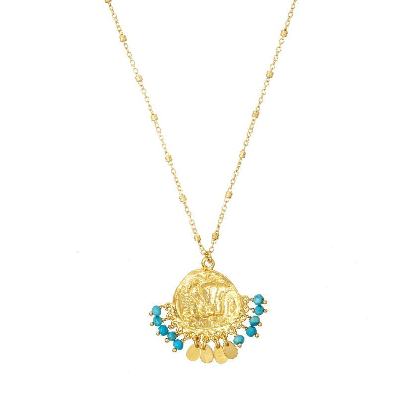 Gold necklace with a circular pendant and turquoise stones on a white background
